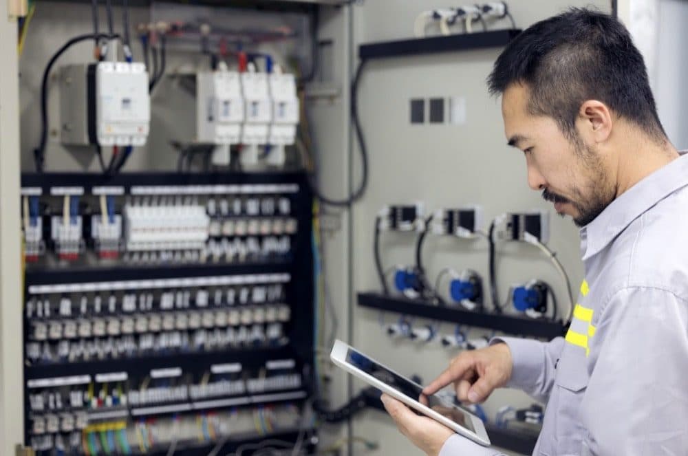 Apprentice electrician working on a control panel